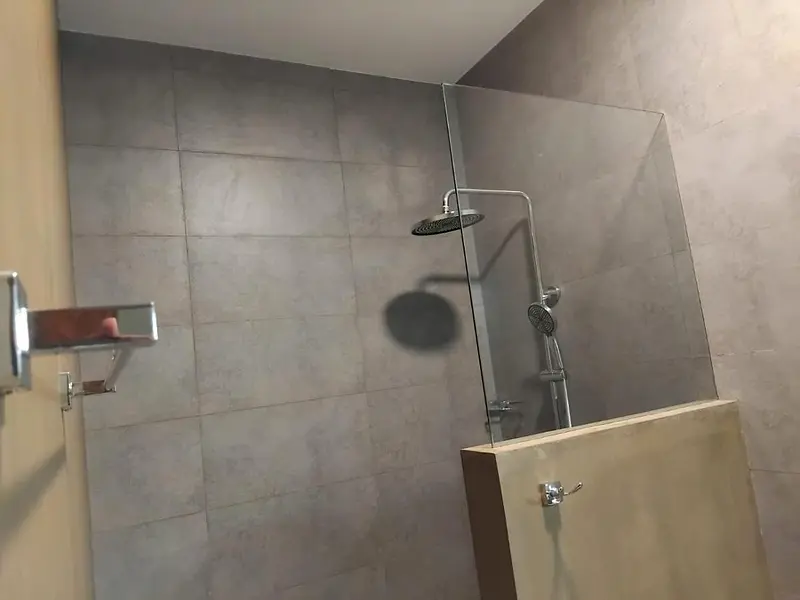 Walk-in rain shower behind a glass screen in the private bathroom